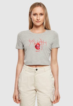 T-shirt gris court à manches courtes avec un graphique rouge d'une tête de mort et des éclairs. Le matériau semble doux ; design ajusté.