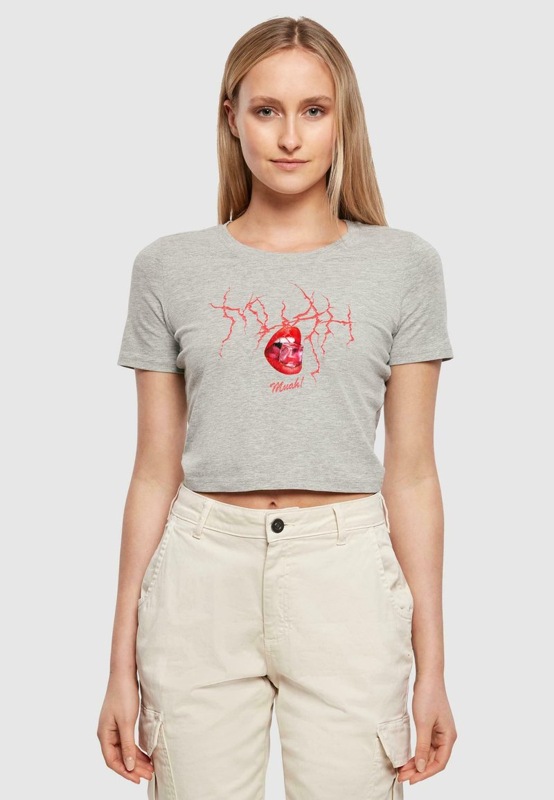 Camiseta gris corta con mangas cortas que presenta un gráfico rojo de una calavera y rayos. El material parece suave; diseño ajustado.