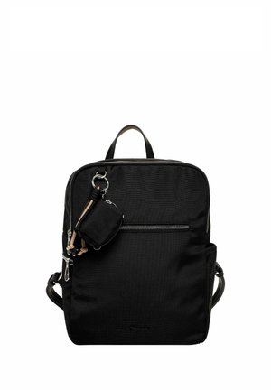 Schwarzer quadratischer Rucksack mit vorderer Reißverschlusstasche und angebrachtem kleinem Beutel-Schlüsselanhänger vor weißem Hintergrund.