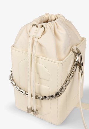 Bolso tipo cubo de cuero crema con cierre de cordón y detalle de correa de cadena geométrica plateada.