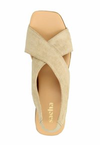 Beige suède sandaal met kruislings banden, een open teen ontwerp en een gladde, lichtbruine binnenzool met het merknaam "sacha".