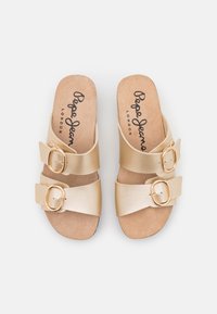 Sandali in finta pelle marroni con due cinturini regolabili e fibbie dorate. Intersuola morbida con il marchio "Pepe Jeans London". Design a suola piatta.