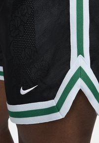 Pantalones cortos deportivos negros con ribetes blancos y verdes, que presentan un logo de Nike en blanco en la parte inferior izquierda.