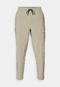 Beige cargo pants featuring an elastic waistband with a drawstring, tapered legs, and side pockets. Made from lightweight fabric.