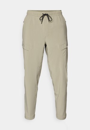 Beige Cargo-Hosen mit einem elastischen Bund und Kordelzug, tapered Beinen und seitlichen Taschen. Hergestellt aus leichtem Stoff.
