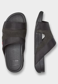 Svarta FitFlop-sandaler med en dual-texturerad design, mjuka tyg- och mockastänger, en vadderad fotbädd och en slitstark gummisula.
