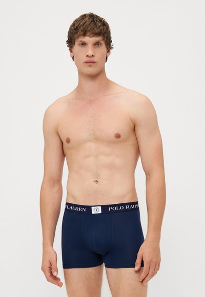 Boxeri scurți din bumbac de culoare albastru închis, cu o nuanță uniformă, având un brâu elastic inscripționat "POLO RALPH LAUREN." Design simplu, fitted.