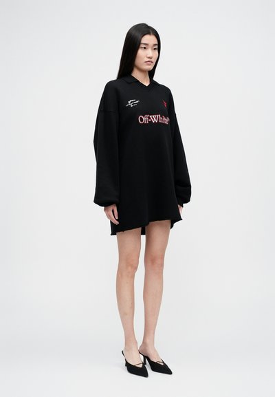 Liela izmēra melns polo kleita, izgatavota no kokvilnas, ar sarkano izšūto "Off-White" logotipu un šuvju detaļām, ar nedaudz saplaisājušu apakšmalu.