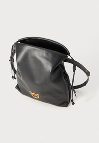 Črna usnjena torba s prepognjenim vrhom, z vrvico za zapiranje, nastavljivim naramnikom in zlatim logotipom na sprednji strani.