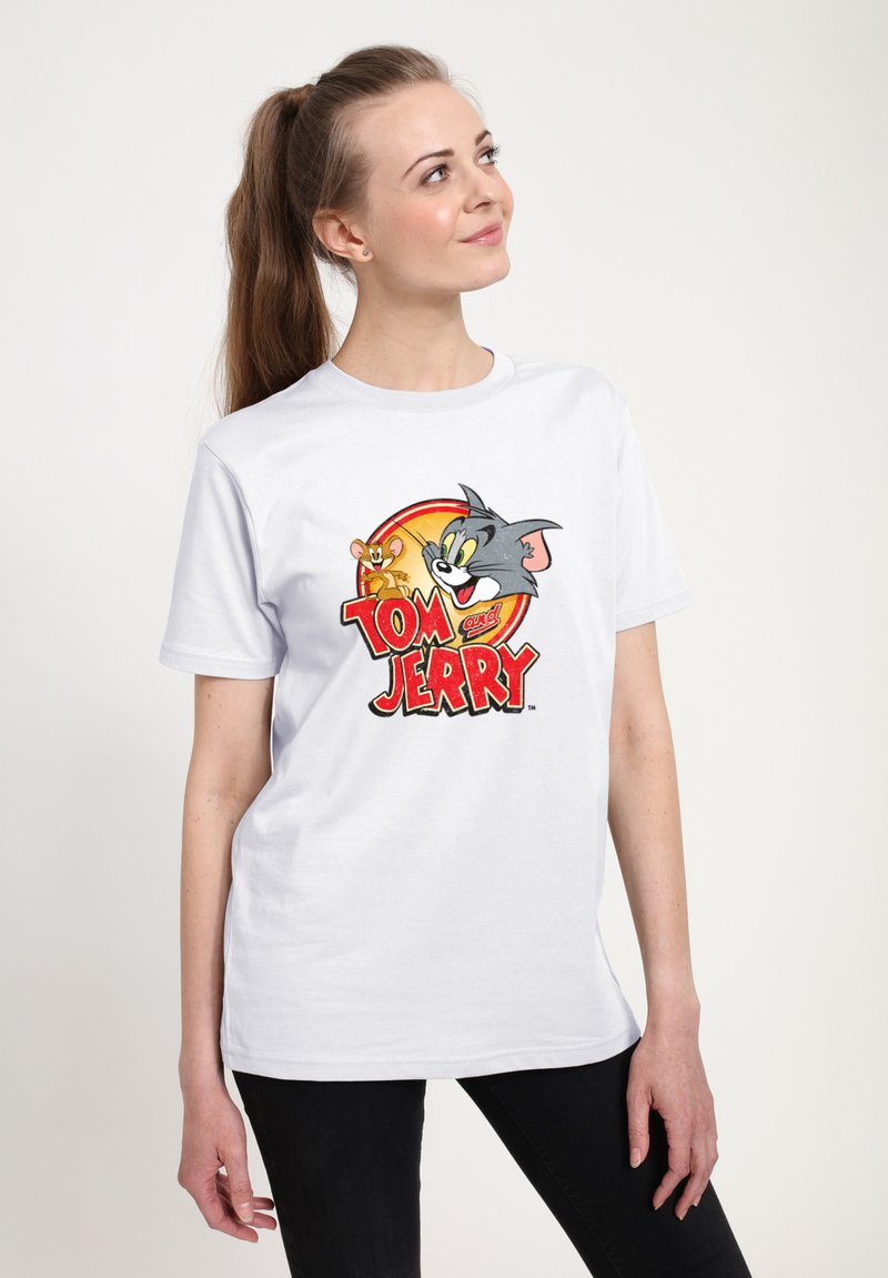Hvid bomulds t-shirt med et farverigt grafik af Tom og Jerry, med et rundt design og med fed skrift i rød. Korte ærmer og afslappet pasform.