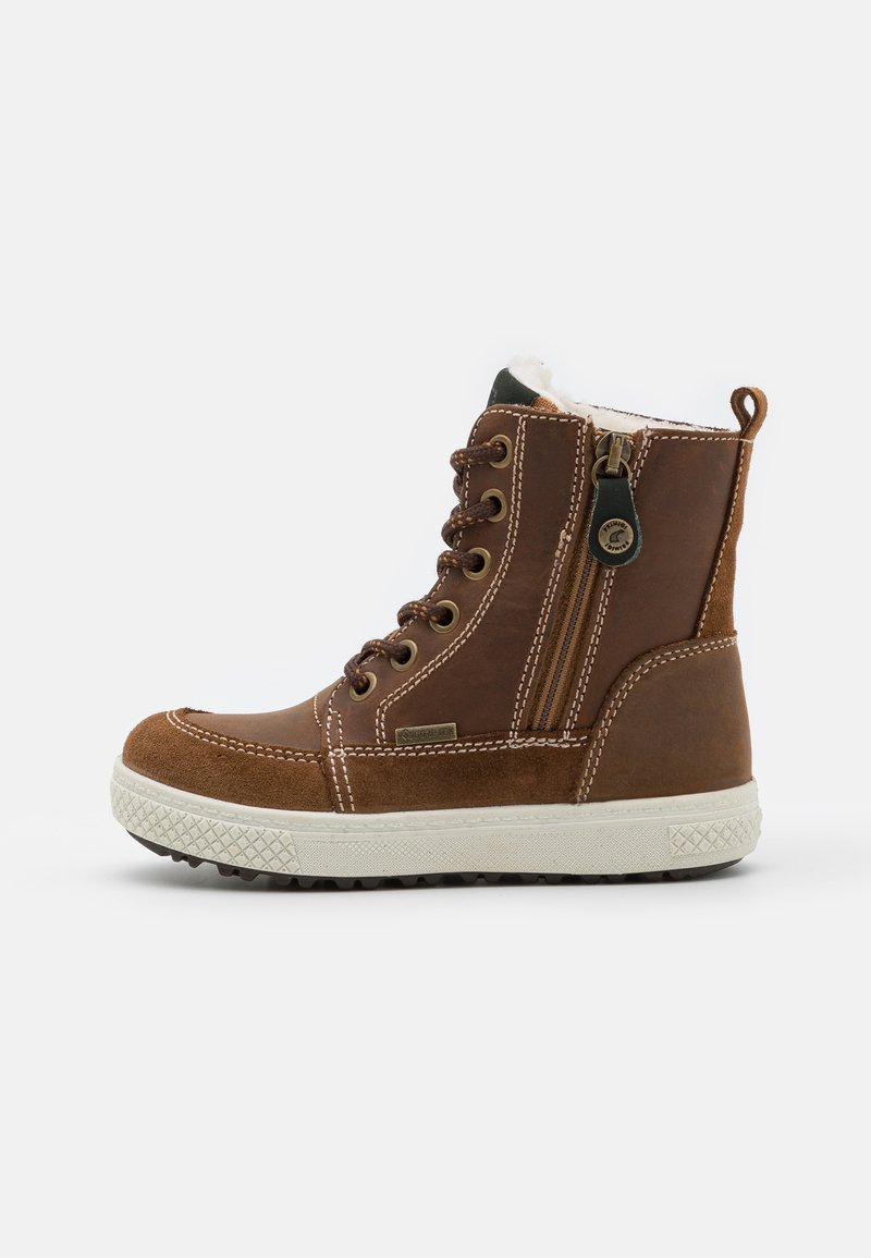 Botas marrones hasta el tobillo de cuero, con un interior forrado de piel, cremallera en el lateral y una suela de goma blanca texturizada.