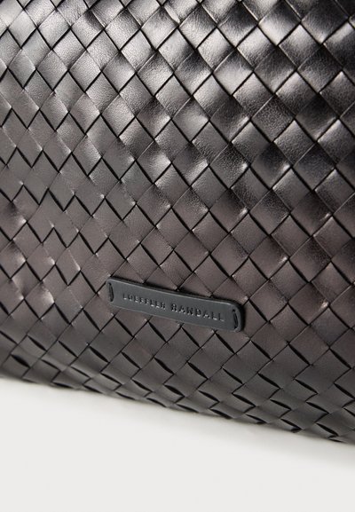 Μαύρη υφασμένη δερμάτινη τσάντα με υφή στην επιφάνεια, με ορθογώνια ετικέτα με ανάγλυφη επιγραφή "LOEFFLER RANDALL" σε μαύρο χρώμα.