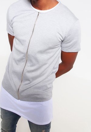 T-shirt gris à manches courtes avec une fermeture zippée centrale métallique et un ourlet blanc. Confectionné dans un tissu lisse avec une coupe ajustée et un col rond.