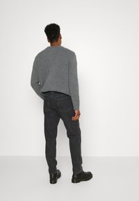 Weekday BARREL - Calças de ganga de corte afunilado - tar black