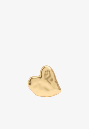 Objet doré lisse et brillant en forme de cœur légèrement irrégulier avec des bords arrondis sur fond blanc.
