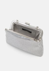 Silver clutch bag with a mesh design, featuring a metallic frame and clasp closure. Interior has a subtle fabric lining for organization.