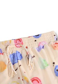 Pantalones cortos multicolores hechos de tela ligera con fondo beige, con un estampado de helados, cintura elástica y cordones ajustables.