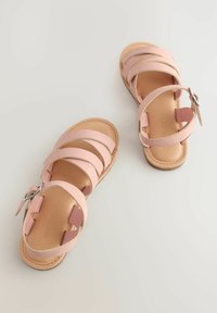 Sandali in pelle rosa con multiple cinghie incrociate e una fibbia laterale. La suola è di un beige chiaro con una texture liscia.