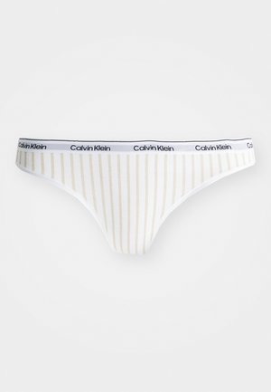 Calvin Klein thong in white cotton with thin vertical gold stripes. Features a black logo waistband and a smooth, stretchy texture.