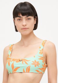 Haut de bikini vert avec un motif floral orange, décolleté carré et larges bretelles ; fabriqué à partir d'un matériau lisse et extensible.