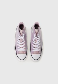 Zapatillas altas moradas con acabado brillante, cordones blancos, puntera negra y suela de goma. Presenta una etiqueta de logo en el lateral.