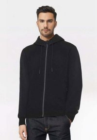 Felpa nera con zip, dotata di cappuccio regolabile, polsini a costine e una texture liscia. Presenta tasche laterali e un design a taglio dritto.