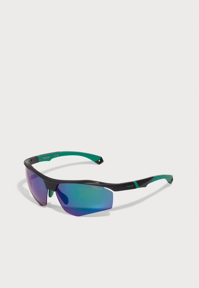 Sport sunglasses with a black frame and green rubber accents. Mirrored lenses exhibit a gradient of blue to purple. Slim, aerodynamic design.