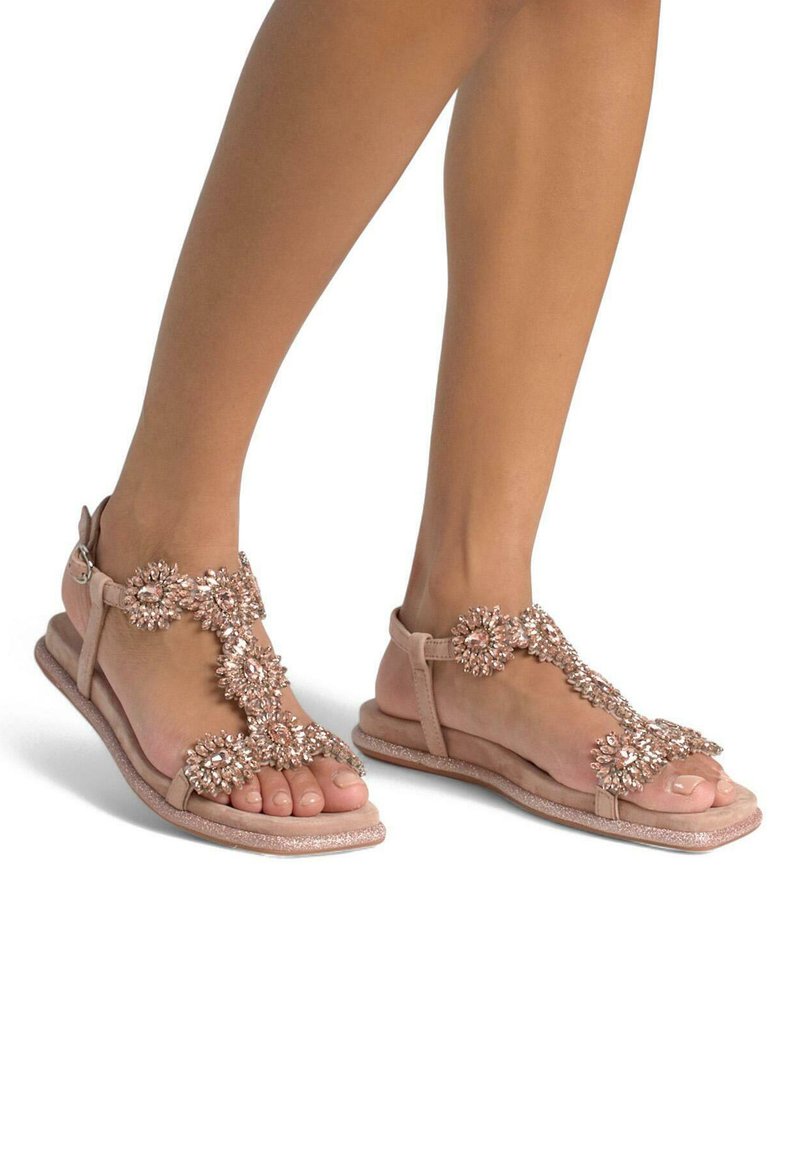 Sandali beige con decorazioni floreali e strass, suola piatta e cinturino alla caviglia. Morbido tessuto scamosciato con accenti glitterati.