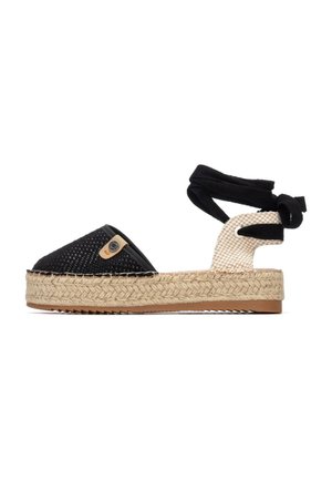 Alpargata en blanco y negro con suela de yute tejido, parte superior de tela y lazos para atar al tobillo. Patrón de cuadros notable en el talón y un pequeño detalle de logotipo.