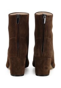 Stivali alla caviglia in suede marrone con tacco a blocco alto, dotati di una cerniera sul retro e cuciture decorative sui lati. Fodera interna liscia.