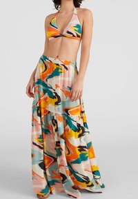 Haut de bikini multicolore avec bonnets triangulaires et bretelles nouées au cou, assorti à une jupe longue fluide à motifs, avec des volants superposés.