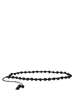 Schwarze Tasbih-Gebetsperlen, die auf einer Schnur mit einer Quaste an einem Ende aufgefädelt sind, in lockerer ovaler Form auf weißem Hintergrund angeordnet.