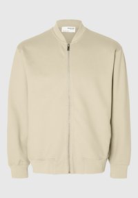 Chaqueta bomber beige con cremallera, cuello, puños y dobladillo acanalados, que cuenta con dos bolsillos delanteros y una tela lisa y sencilla.