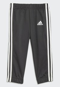 Pantalons de sport noirs en tissu lisse, avec un logo blanc et trois rayures blanches verticales sur les côtés. Taille élastique.