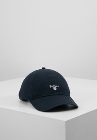 Marineblauwe baseballpet van stof met gestikte naden en een geborduurd "Barbour"-logo aan de voorkant, met een gebogen klep.