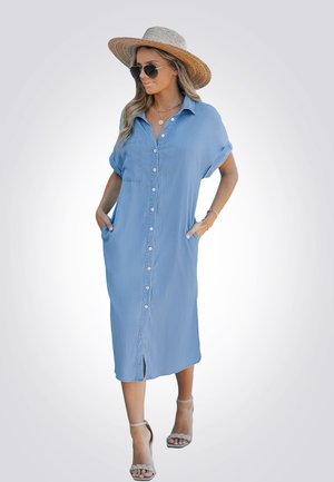 Vestido azul claro, hasta la rodilla, de botones con mangas cortas, bolsillos y un corte relajado. Cuenta con un bolsillo frontal y aberturas laterales.