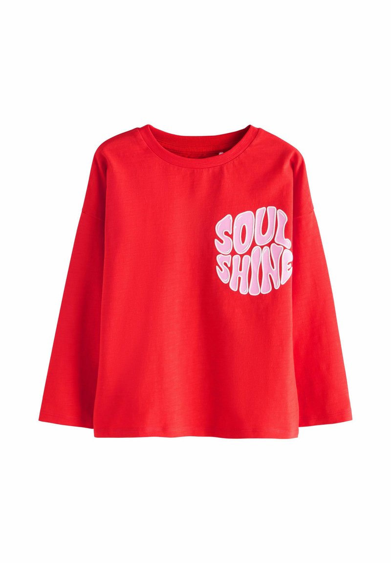 Chemise rouge à manches longues, avec une coupe ample, présentant des lettres bulle roses avec l'inscription "SOUL SHINE" sur le haut à gauche de la poitrine.
