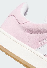 Baskets en daim rose avec une bande en cuir blanc, dotées d'une semelle extérieure en caoutchouc texturée et d'un col rembourré pour le confort. Coutures ton sur ton incluses.