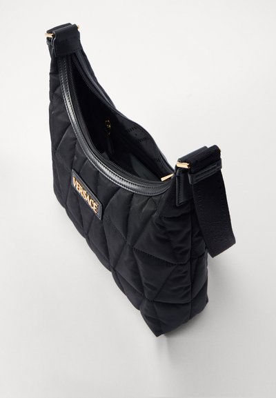Geantă de umăr neagră, matlasată, din nailon, cu logo Versace de culoare aurie, având închidere cu fermoar și curea ajustabilă.