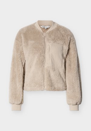 Beige faux fur bomber jacket with a zip front, ribbed cuffs, and a single patch pocket. Soft texture and cropped fit.