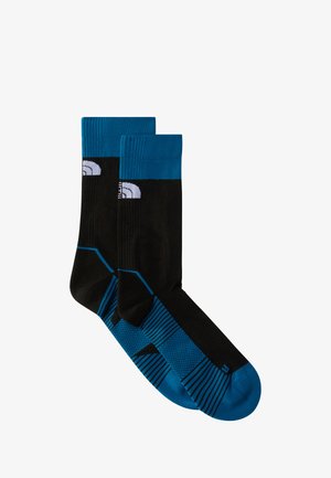 Czarne skarpetki z turkusowym mankietem i palcem. Posiadają wypukłą teksturę oraz prążkowane wzory. Logo umieszczone na górnej części.
