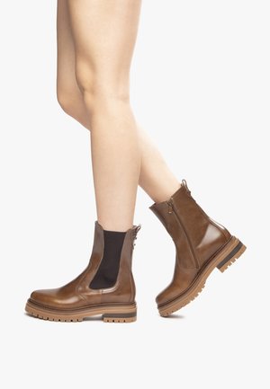 Brown leather ankle boots with zip closure, elastic side panels, textured rubber soles, and a smooth finish.