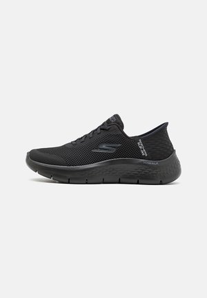 Czarne sneakersy Skechers Go Walk Slip-Ins z cholewką z siateczki, sznurowaniem, fakturowaną podeszwą i logo Skechers po boku oraz na języku z tyłu buta.