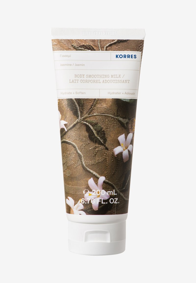 Tube de lait lissant pour le corps, 200 mL. Présente un design floral sur un fond brun texturé, avec un capuchon blanc et une étiquetage en plusieurs langues.