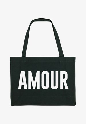 Zwarte canvas tote bag met opvallende witte "AMOUR" tekst. Rechthoekige vorm met twee lange handgrepen om te dragen. Glad textuur.