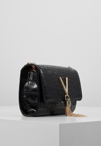 Borsa in pelle nera con effetto coccodrillo, dotata di accessori in metallo color oro, caratterizzata da un tassello a catena e un design strutturato.