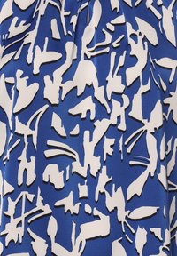 Niebieska tkanina z abstrakcyjnym wzorem w białym kolorze z czarnymi konturami, ukazująca połączenie kształtów geometrycznych i organicznych. Gładka tekstura.