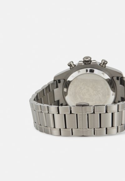 Silver metal wristwatch featuring a linked bracelet, round case, and textured dial with chronograph sub-dials and a logo on the back.