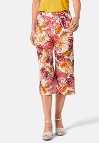 Pantalons cropped à motifs avec un fond blanc présentant des motifs de feuilles rouges, oranges et brunes. Taille élastique et coupe ample.