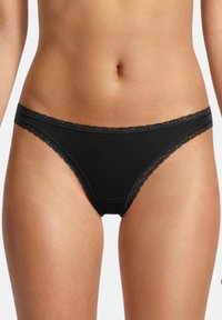 Biancheria intima nera con pizzo, progettata a vita bassa. Realizzata in un tessuto morbido, presenta una texture liscia e dettagli in pizzo delicato lungo i bordi.